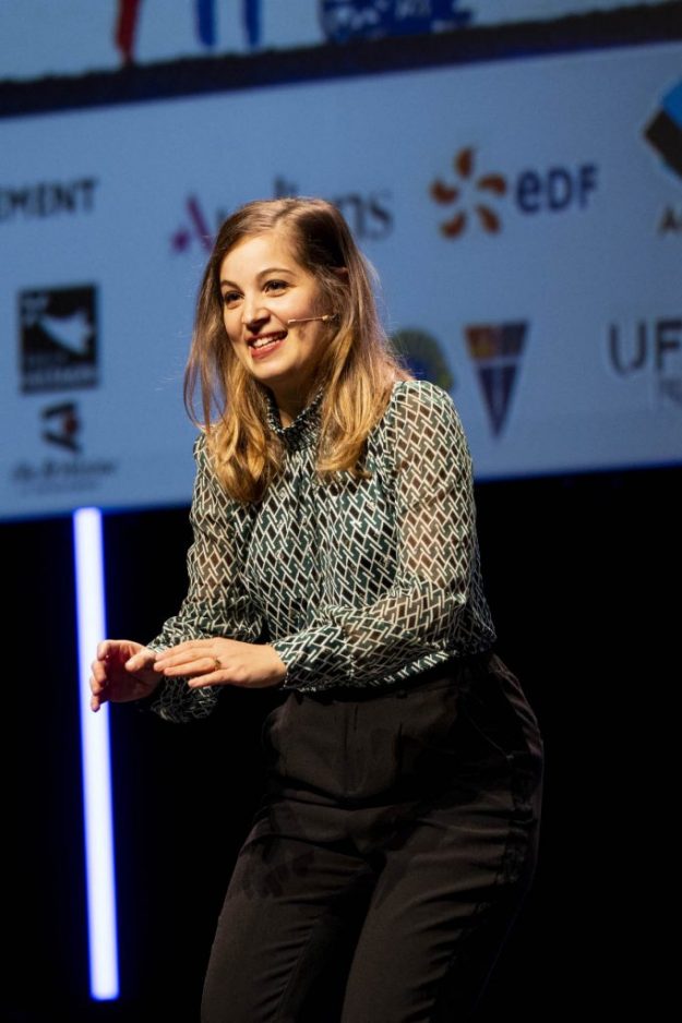 Dora Blasberg, Présidente de ProAdapt anime un Atelier de Prévention des TMS géant sur scène lors du Festival Regards Croisés "Métiers & Handicaps" 2023